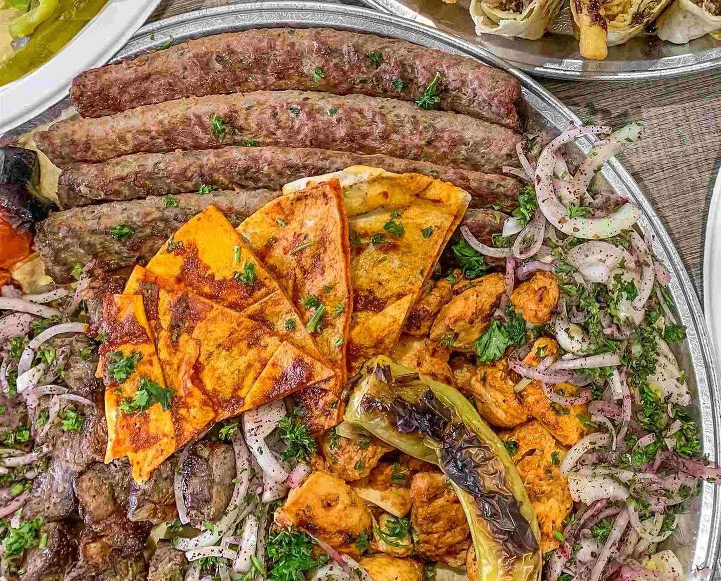 Aljazeera BBQ platter with kabab skewers, chicken tawook, grilled pepper, sumac onions and toasted pita